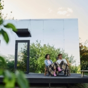 Couple sitting on a deck in front of their home | Featured image for Advantages of a Steel Frame blog on Keppel Coast Steel Frames & Trusses.