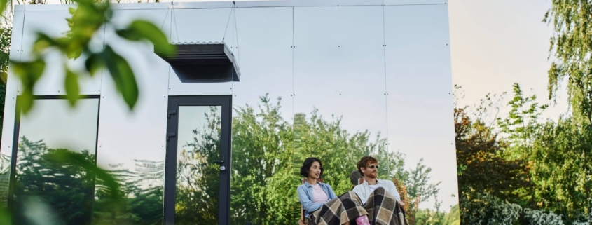 Couple sitting on a deck in front of their home | Featured image for Advantages of a Steel Frame blog on Keppel Coast Steel Frames & Trusses.