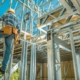 Worker climbing down a ladder inside a house that is being built | Featured image for Choosing the Right Supplier blog on Keppel Coast Steel Frames & Trusses.