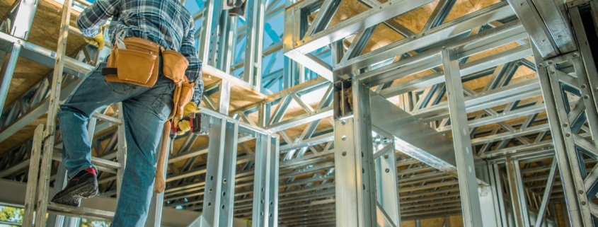 Worker climbing down a ladder inside a house that is being built | Featured image for Choosing the Right Supplier blog on Keppel Coast Steel Frames & Trusses.